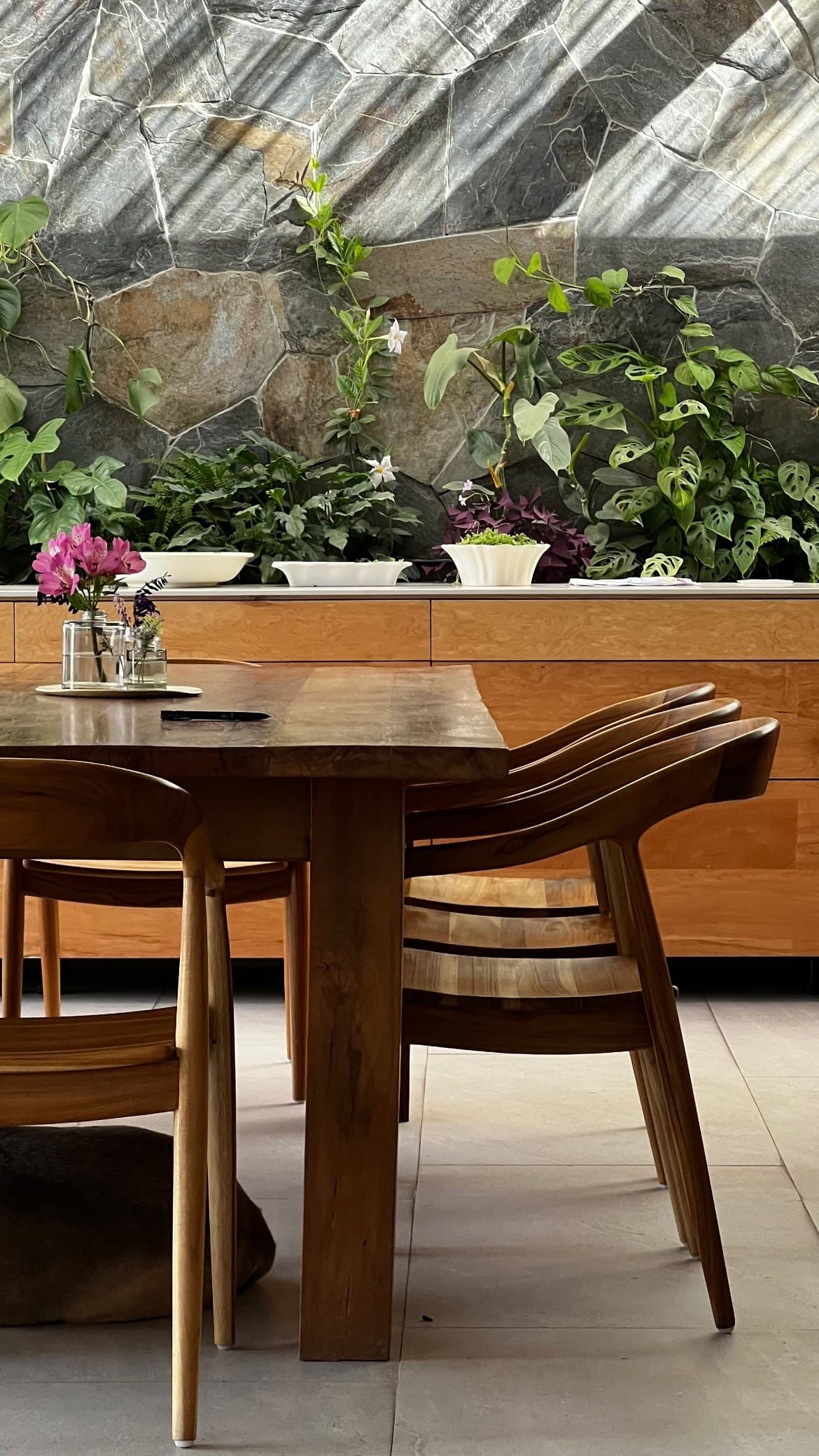 Comedor en madera maciza junto al muro de piedra interior — Casa Fátima