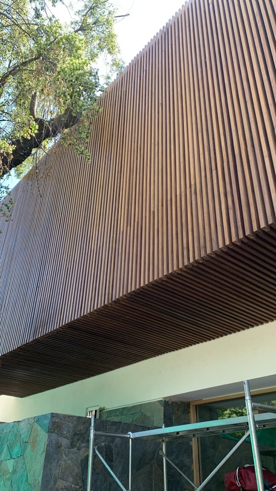 Fachada de listones verticales de madera durante la obra — Casa Fátima